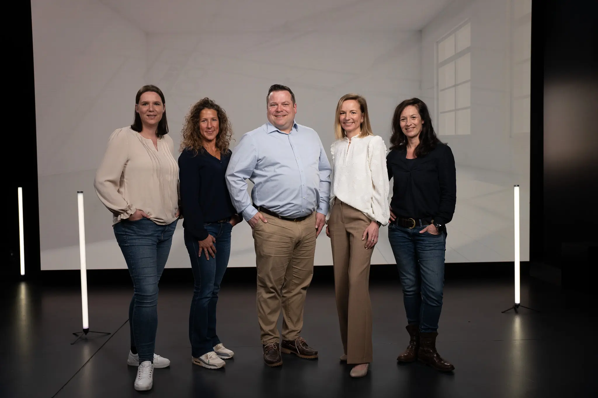 Annette Lambertz, Susanne Althoff, Christian Kempf, Angela Simonis und Sonja Hülsers stehen vor einem grauen Hintergrund und lächeln in die Kamera