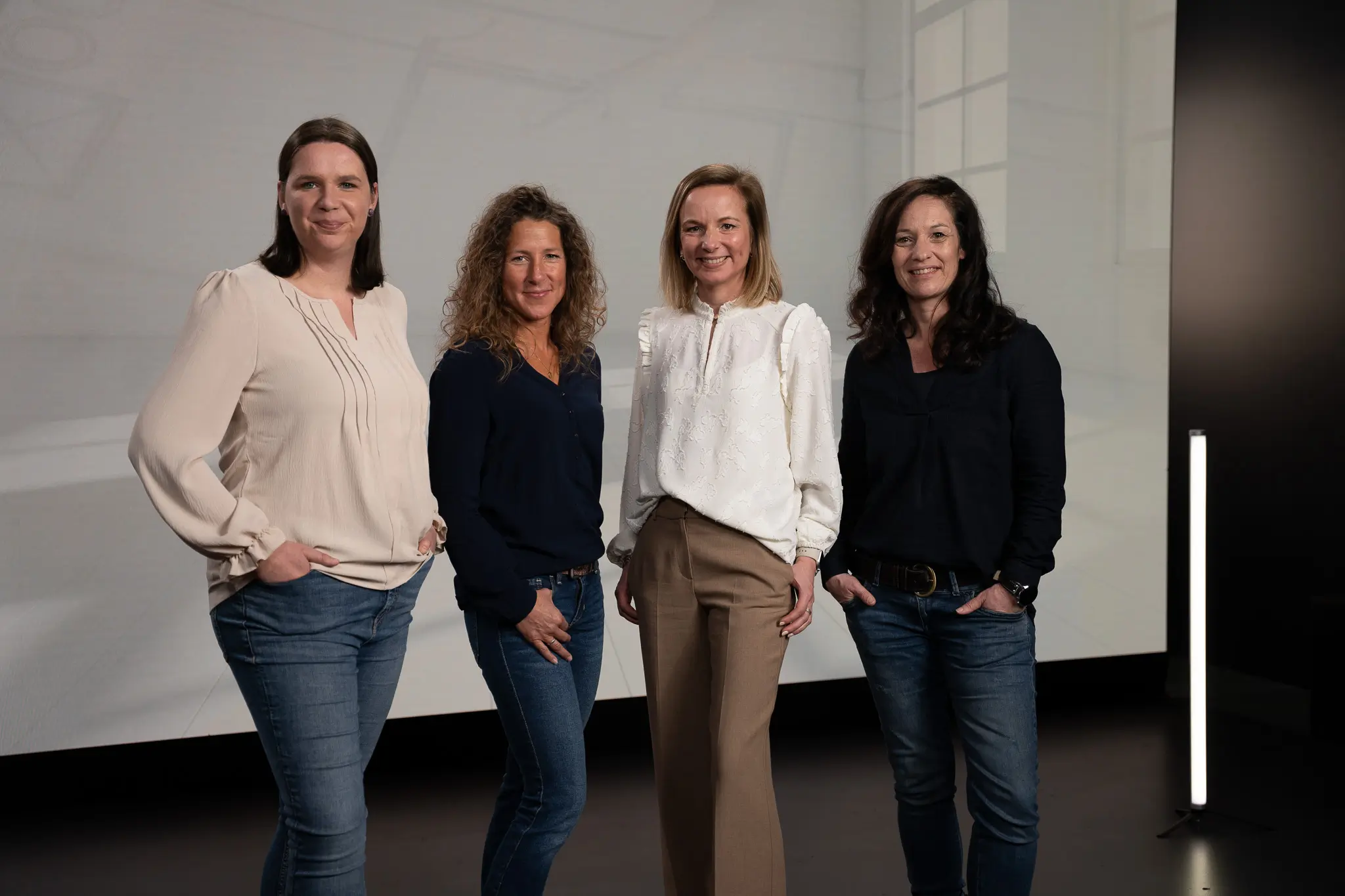 Annette Lambertz, Susanne Althoff, Angela Simonis und Sonja Hülsers stehen vor einem grauen Hintergrund und lächeln in die Kamera